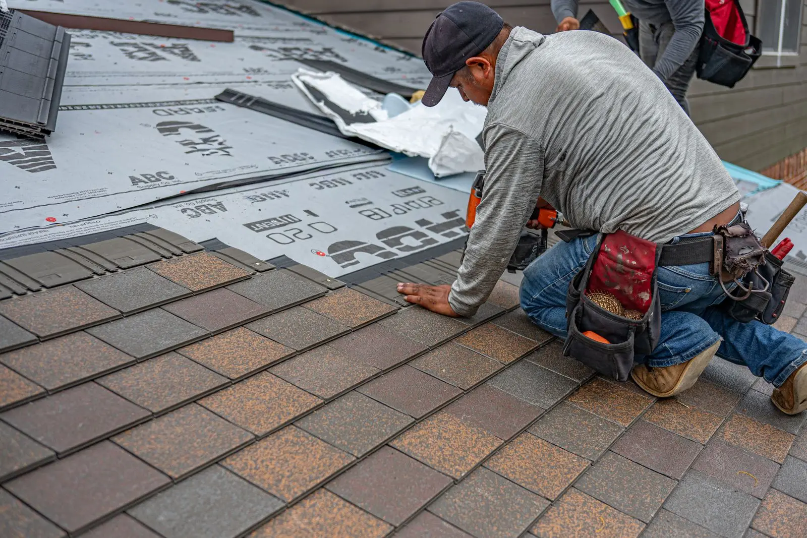 Roofer working on an asphalt shingle roof
